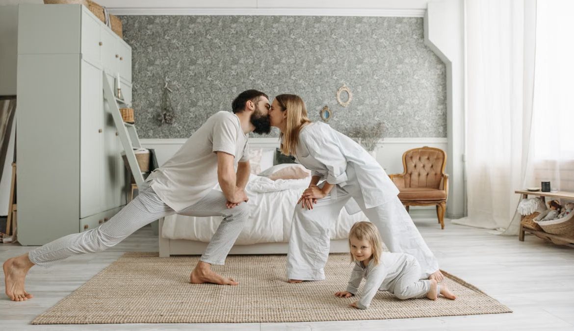 A family enjoying playful bonding moments in a stylish, minimalistic bedroom setting.